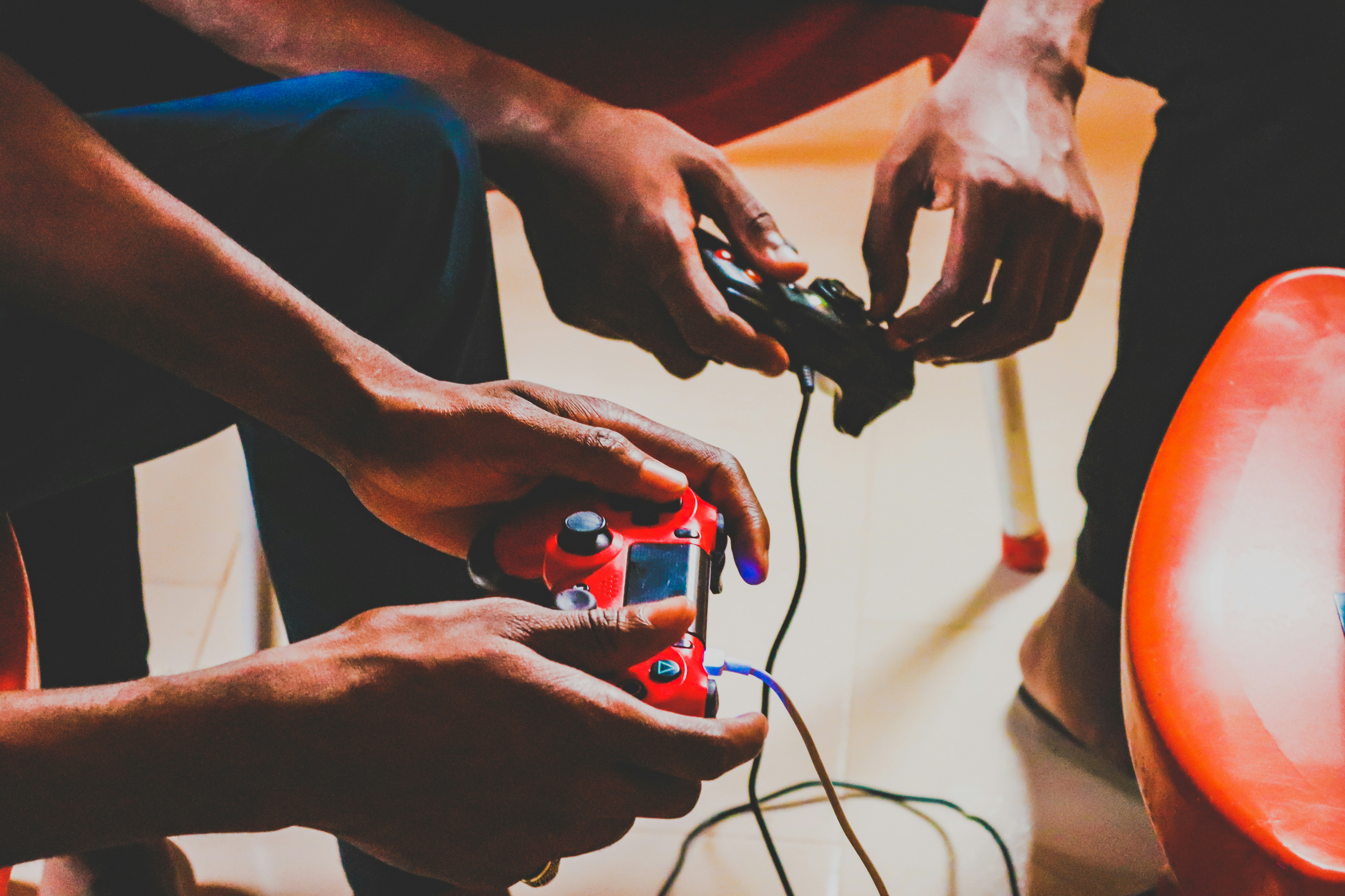 Two gamers using controllers together, illustrating cross-platform play between consoles