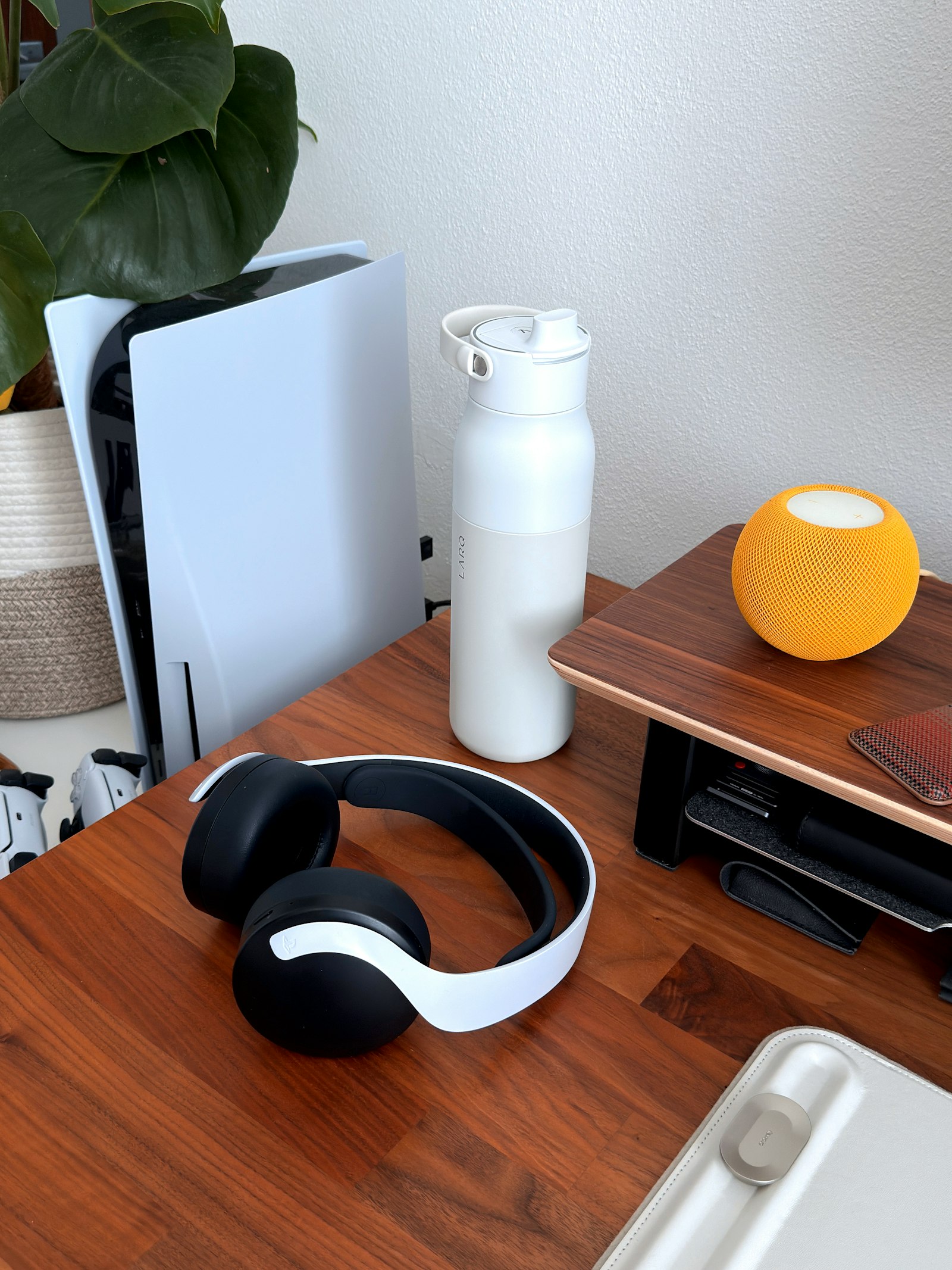 Wireless gaming headset resting on a desk beside a game console, representing the best gaming headsets to buy