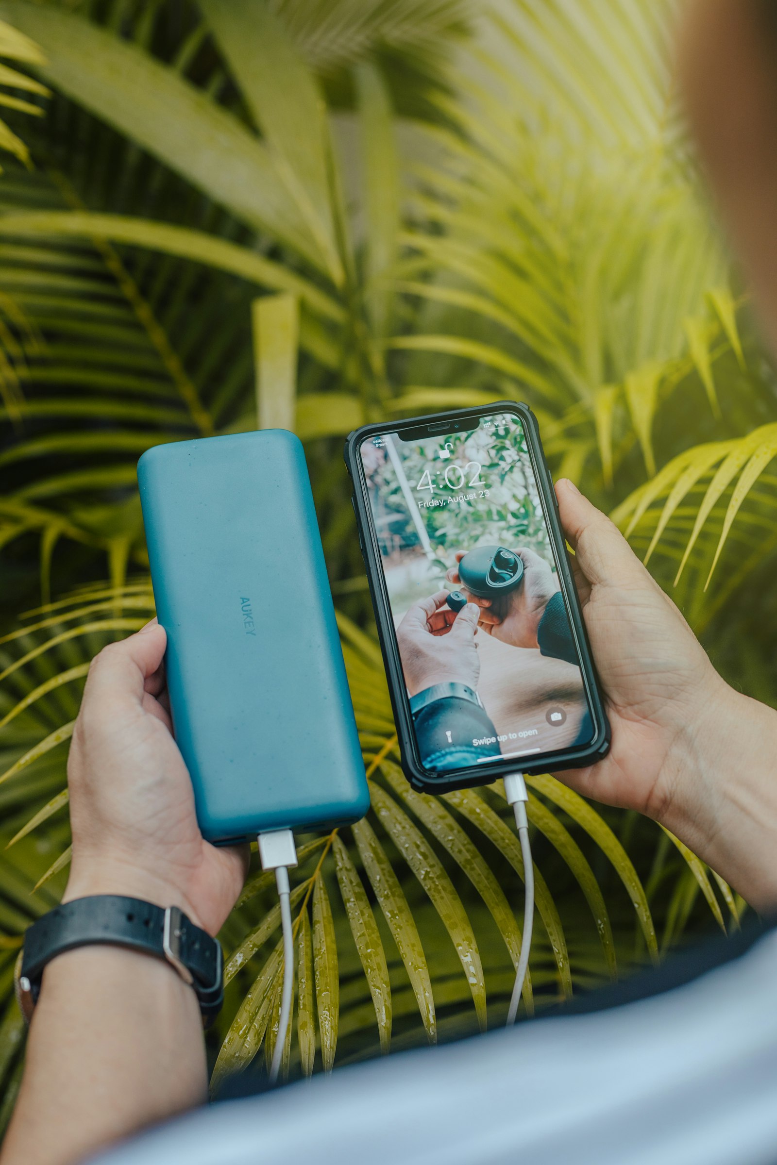 Smartphone connected to a green portable charger power bank, illustrating the best portable chargers to buy