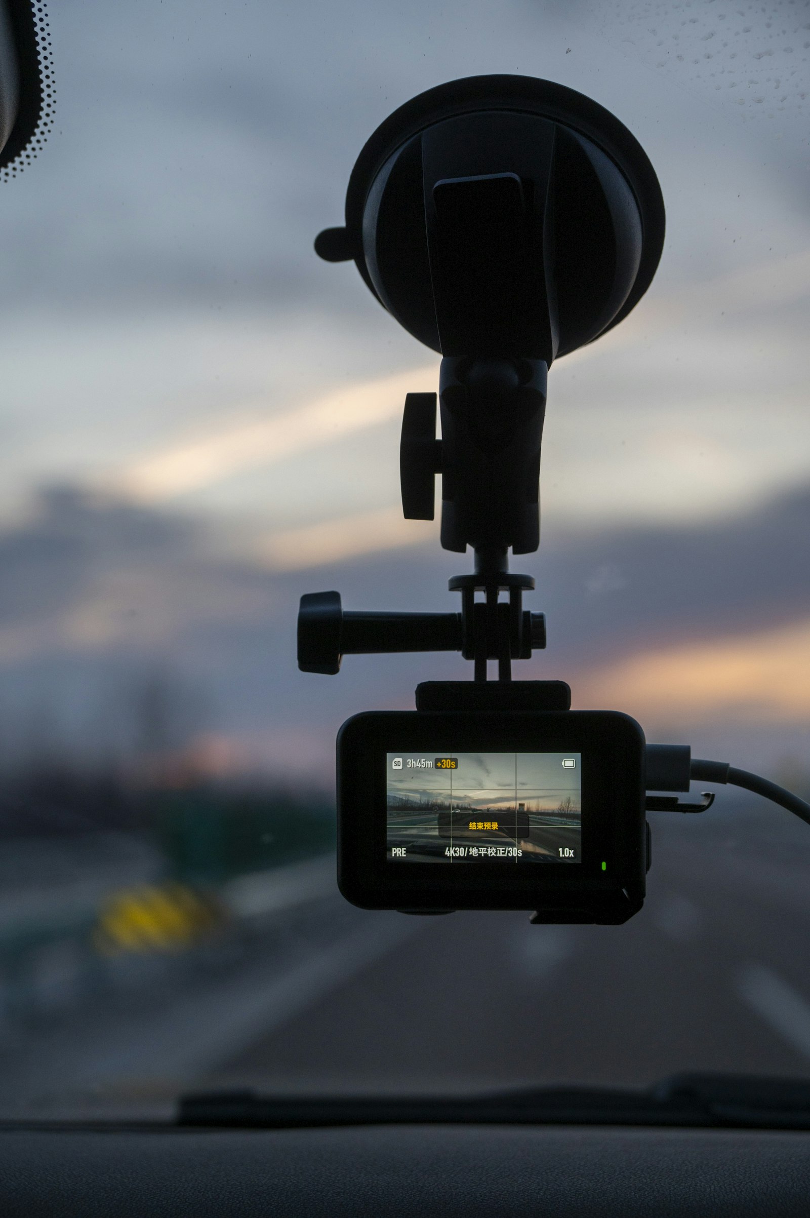 Camera mounted on a car windshield at sunset, a dash cam buying guide illustration